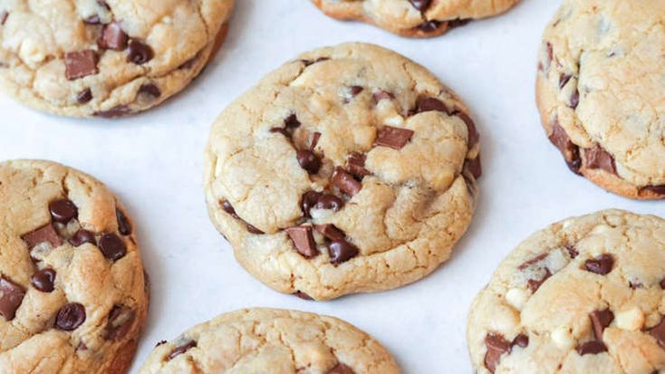 chocolate chip cookies are lined up on a baking sheet and ready to be baked in the oven