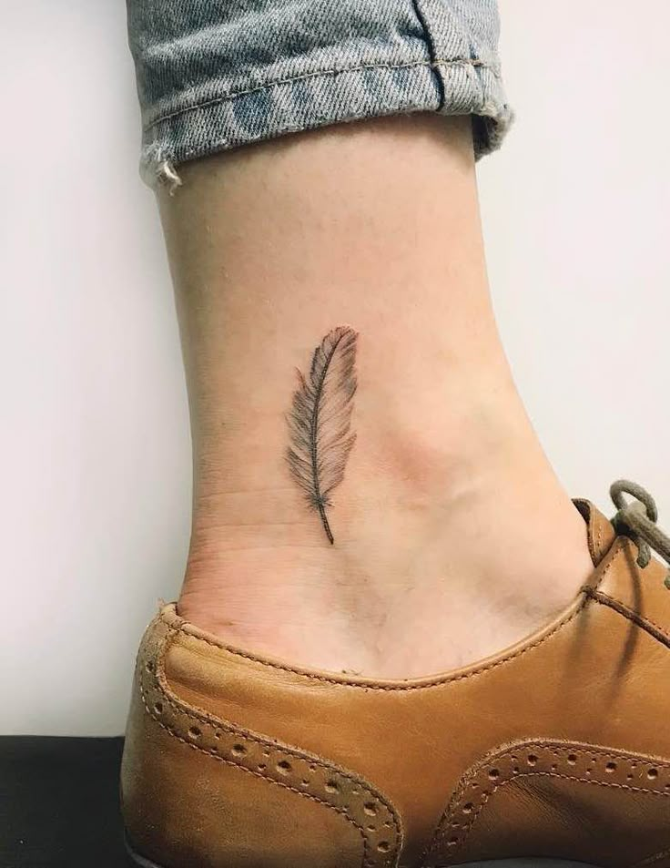 a small feather tattoo on the ankle