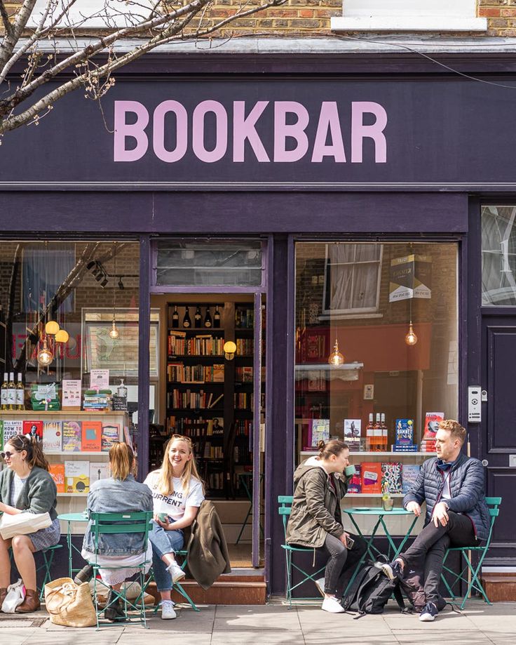 people are sitting outside in front of a book shop