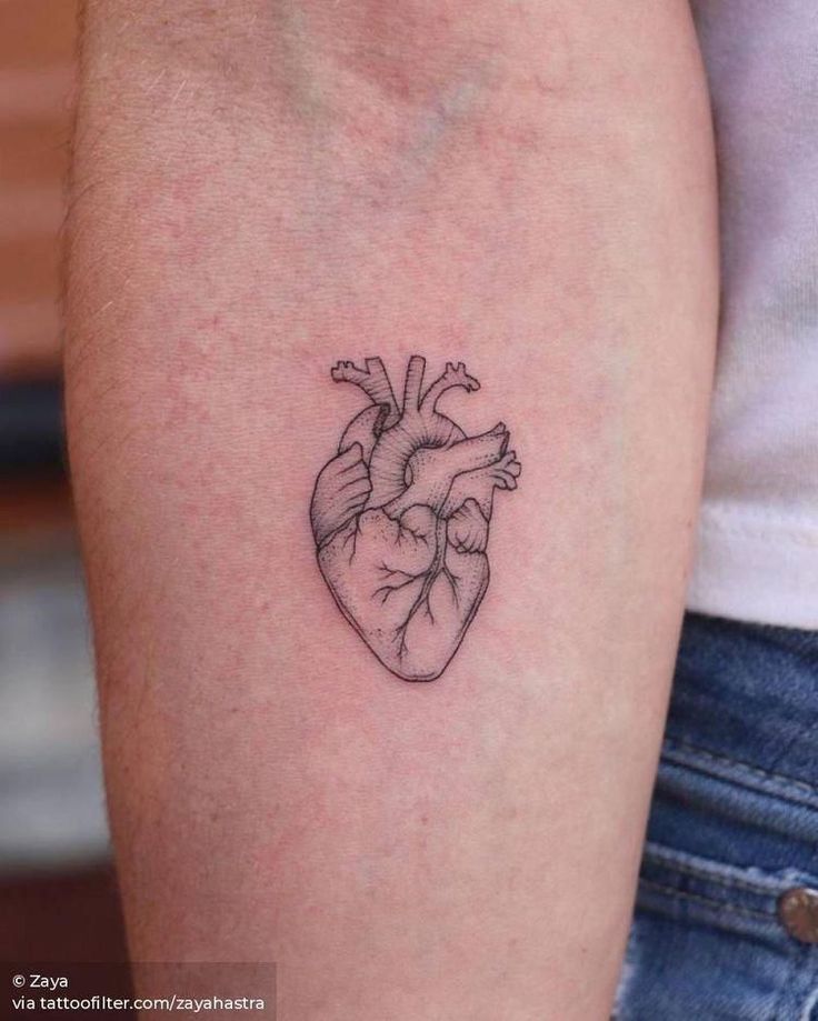 a small heart tattoo on the arm