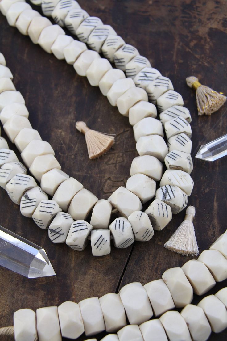 "Large Faceted White Kenyan Recycled Bone Beads, 27\" Necklace, 22mm Beads, African Charms, 4mm Hole, DIY Boho Jewelry, Neutral Focal Bead ✨The MAGIC is in the Details✨ Bead Size: Approx. 22x13mm Strand Length: Approx. 27\" Approximate # of Beads: 40 Hole Size: 4mm Choose from solid white, or white with black stripes Beautifully bold and handcrafted, these beads are carved and faceted in Kenya from large pieces of white ostrich bone. Each piece of bone has been plugged with an inner wooden core. White Wooden Beads Jewelry, White Wooden Beaded Jewelry, White Jewelry With Oval Wooden Beads, White Artisan Heishi Bead Jewelry, White Heishi Beads Artisan Jewelry, Artisan Heishi Beads, White Artisan Beaded Necklaces With Oval Beads, White Beaded Bracelet With Oval Large Beads, Bohemian Round Faceted Beads