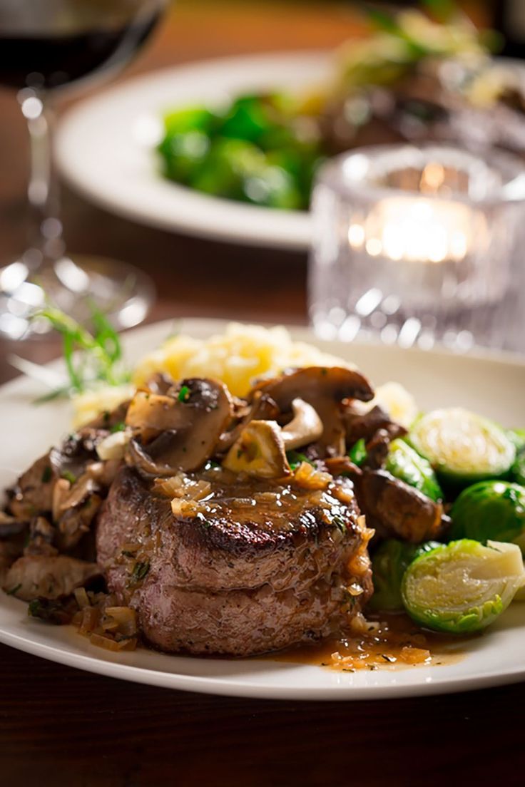 steak with mushrooms and vegetables on a white plate