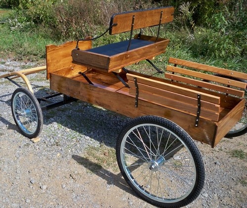 an old fashioned wooden cart with two seats on the front and one seat in the back