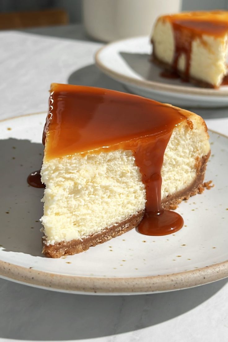 a piece of cheesecake with caramel sauce on top is sitting on a plate