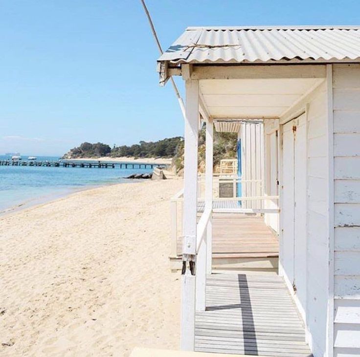 a small white building sitting on top of a sandy beach