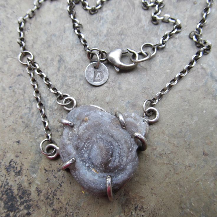 "Druzy Pendant Chalcedony Rose Necklace Sparkling Raw Gemstone Neckpiece: This is a stunning, one-of-a-kind neckpiece featuring a natural, raw, sparkling Chalcedony \"rose\" also known as \"Desert Rose\". is hand set and suspended from a sterling silver chain that I made to be worn at either 19\" or 17\" in length. The stone is a sparkly gray with hints of pale blue and cream. Pendant measures approximately 1\" by 1\". All handmade in my little home studio. Enter my shop: https://www.etsy.com/sh Artisan Jewelry With Raw Stone For Gifting, Artisan Jewelry With Raw Stone For Gift, Gemstone Flower Pendant Necklace For Healing, Agate Raw Stone Jewelry For Jewelry Making, Sterling Silver Pendant With Raw Stone, Agate Raw Stone For Jewelry Making, Silver Pendant With Raw Stone, Silver Raw Stone Pendant Jewelry, Bohemian Sterling Silver Jewelry With Raw Stone