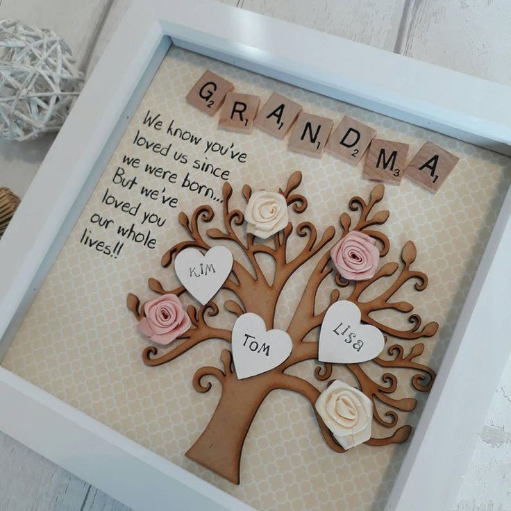 a wooden frame with a tree and two hearts on it that says grandma, we know you've loved us since