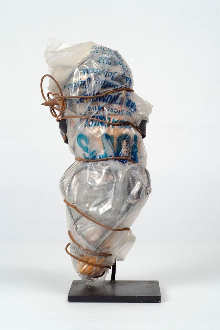 there is a sculpture made out of plastic wrapped in rope and bags on top of it