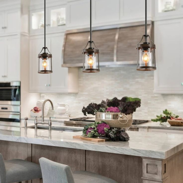 a kitchen with an island and several lights hanging from the ceiling