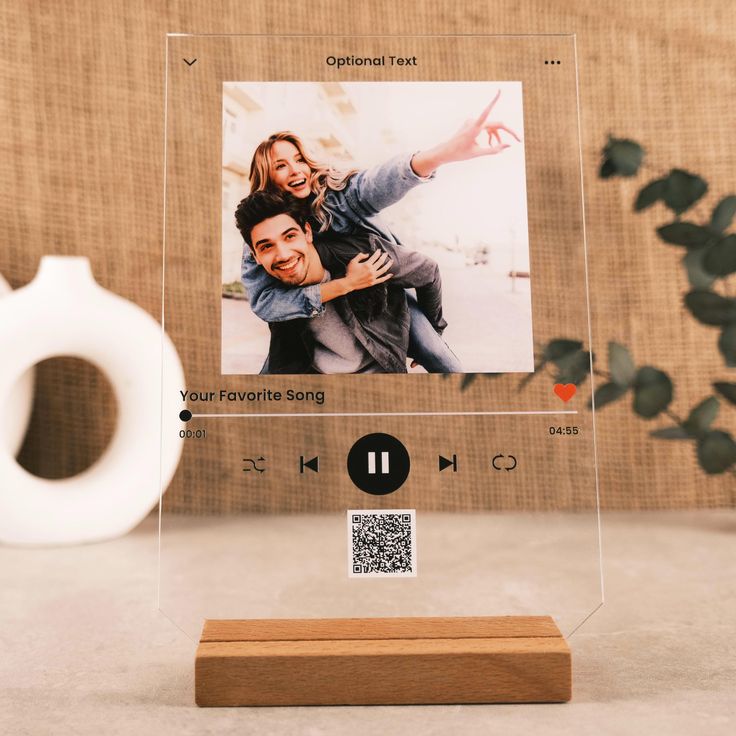 a clear acrylic photo frame with a wooden stand holding an image of a man and woman