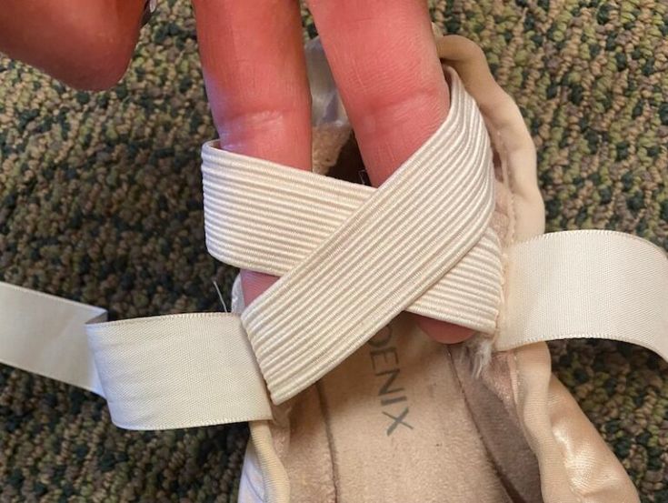 a person with bandages on their feet is holding onto a pair of shoes that are tied together