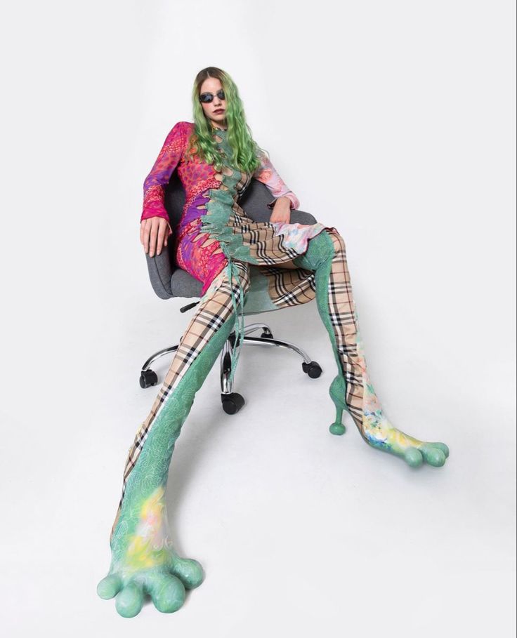 a woman sitting on top of a chair with legs covered in green and pink paint