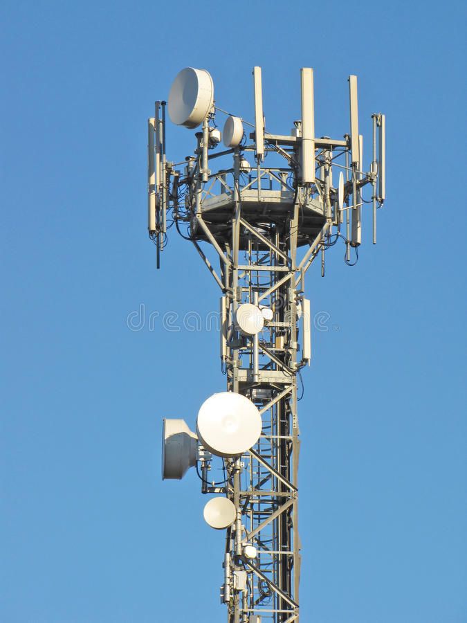 an antenna on top of a tower with blue sky in the background