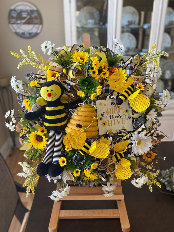 a bouquet of sunflowers, daisies and other flowers is arranged in the shape of a bee