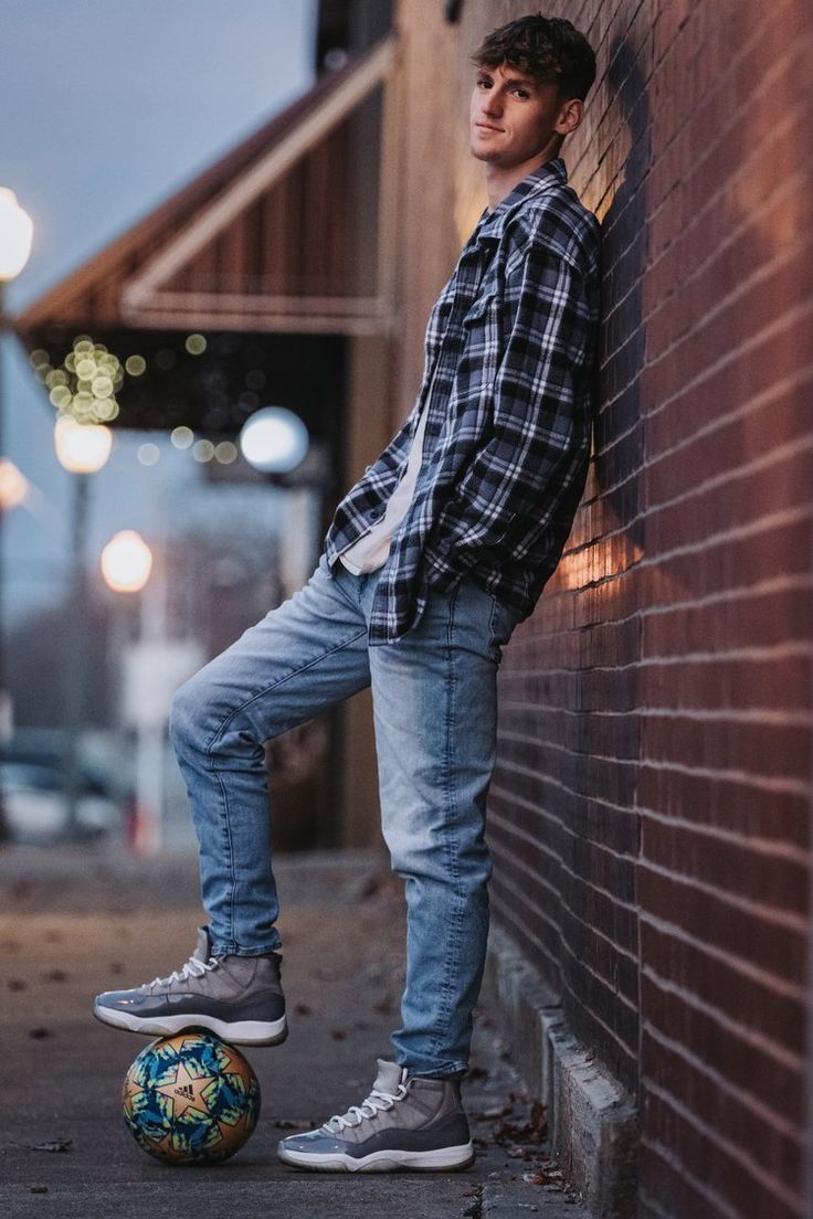 Senior boy posing with soccer ball leaning on a brick wall downtown. Senior Photoshoot Ideas For Guys Soccer, Male Senior Pictures Poses Soccer, Male Senior Photos Soccer, Guy Senior Photos Soccer, Son Senior Picture Ideas, Boy Soccer Senior Picture Ideas, Senior Boy Soccer Photos, Senior Photos For Guys Posing Ideas, Senior Pictures Soccer Boys