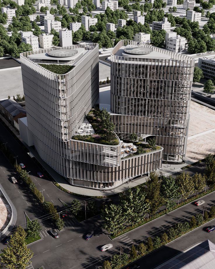 an aerial view of two large buildings in the middle of a city with trees on each side