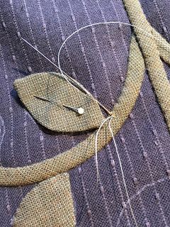 a piece of cloth with some scissors and thread on it that is attached to the fabric