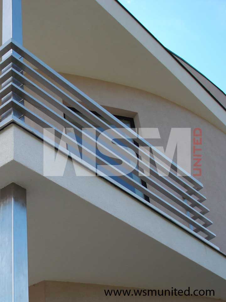 an apartment building with metal balconies and railings on the outside wall, in front of a blue sky