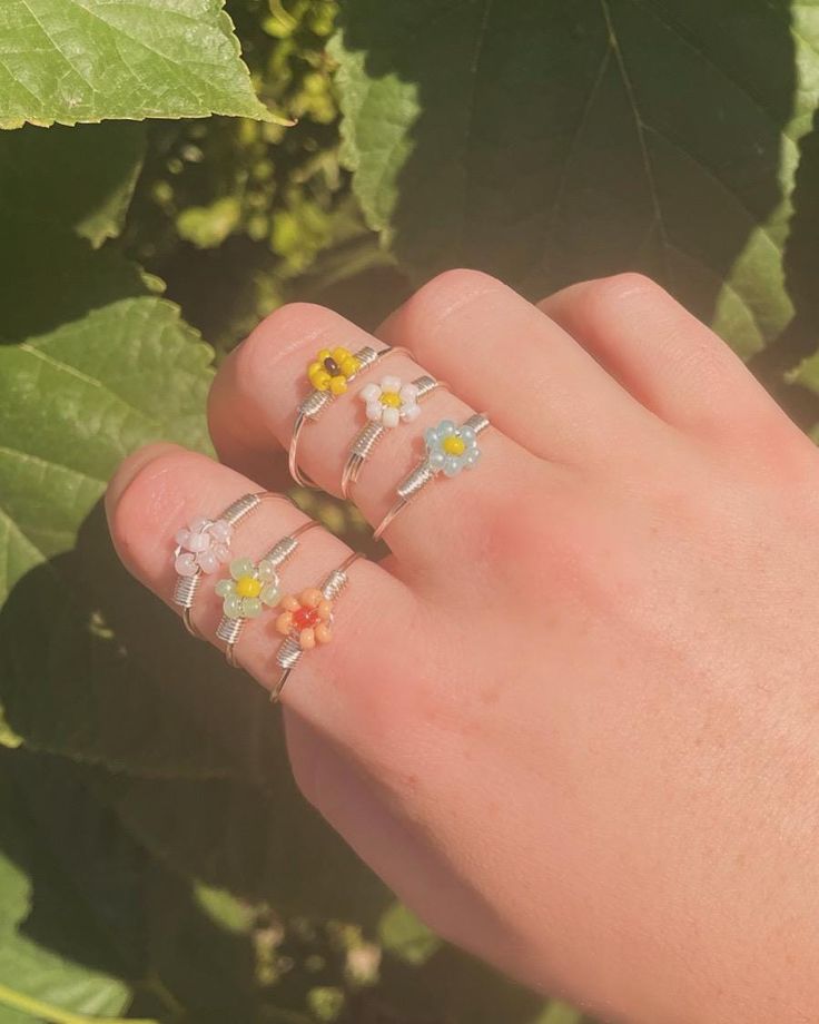 This flower inspired ring is a dainty addition to your ring collection! Made from copper wire and glass seed beads, this ring comes in your choice of a sunflower, daisy, pastel blue, pastel orange, pastel green, or pastel pink. Delicate Flower Jewelry For Summer, Delicate Flower Shaped Summer Jewelry, Delicate Flower Shaped Ring For Spring, Delicate Flower Ring For Spring, Adjustable Crystal Flower Ring, Whimsical Flower Jewelry For Spring, Whimsical Flower-shaped Spring Jewelry, Dainty Flower Ring With Flower Charm, Rose Gold Flower Jewelry For Summer