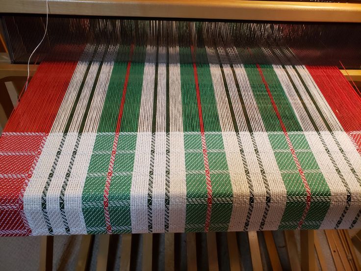 a weaving machine with red, green and white stripes