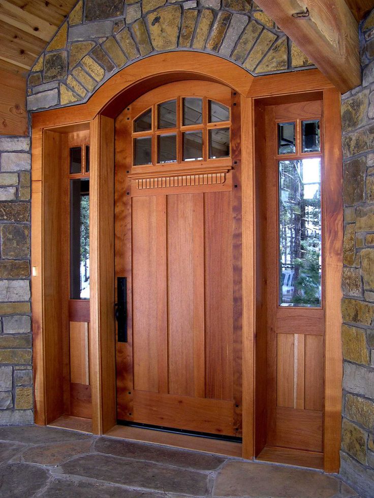 the front door is made of wood and has two sidelights on either side of it