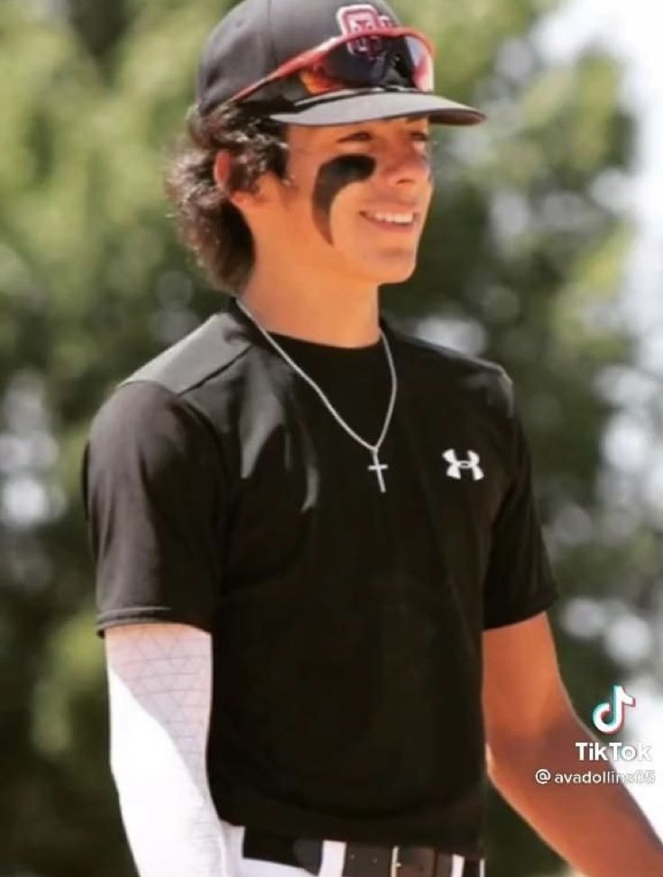 a young man with his face painted like a baseball player is smiling at the camera