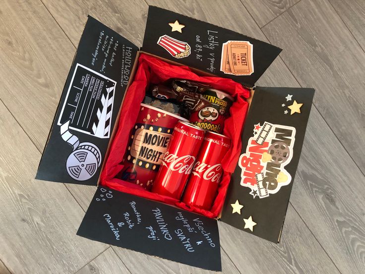 an open coca - cola box on the floor with various stickers and other items