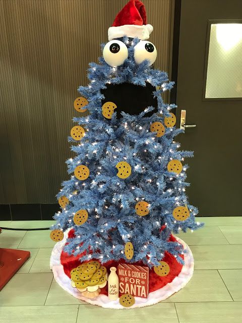 a blue christmas tree with cookies on it and a santa hat sitting on top of it