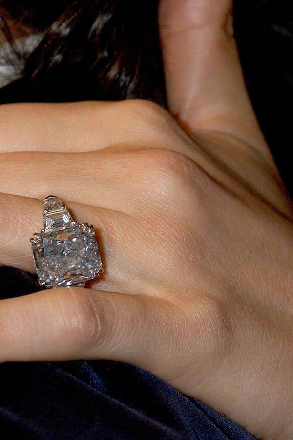 a woman's hand with a diamond ring on it