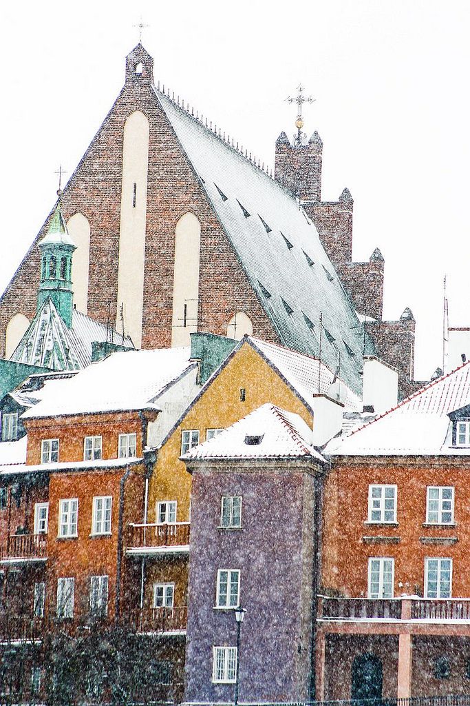 snow covers the roofs of buildings in an urban area