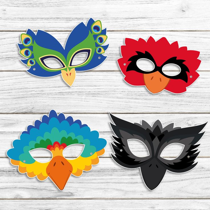 four masks with different colors and designs on wooden background, one is red, one is green