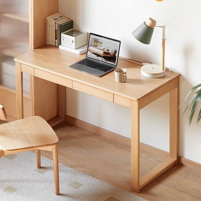 a laptop computer sitting on top of a wooden desk next to a chair and lamp