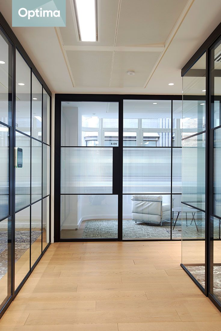 an empty room with glass walls and wooden floors