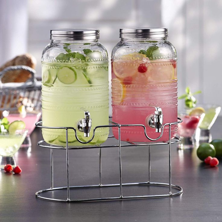 two mason jars filled with drinks sitting on top of a metal rack next to each other