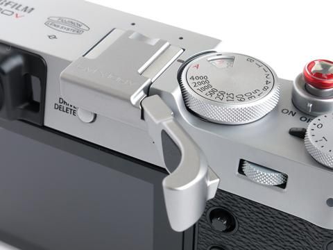 a silver camera with a red button on it