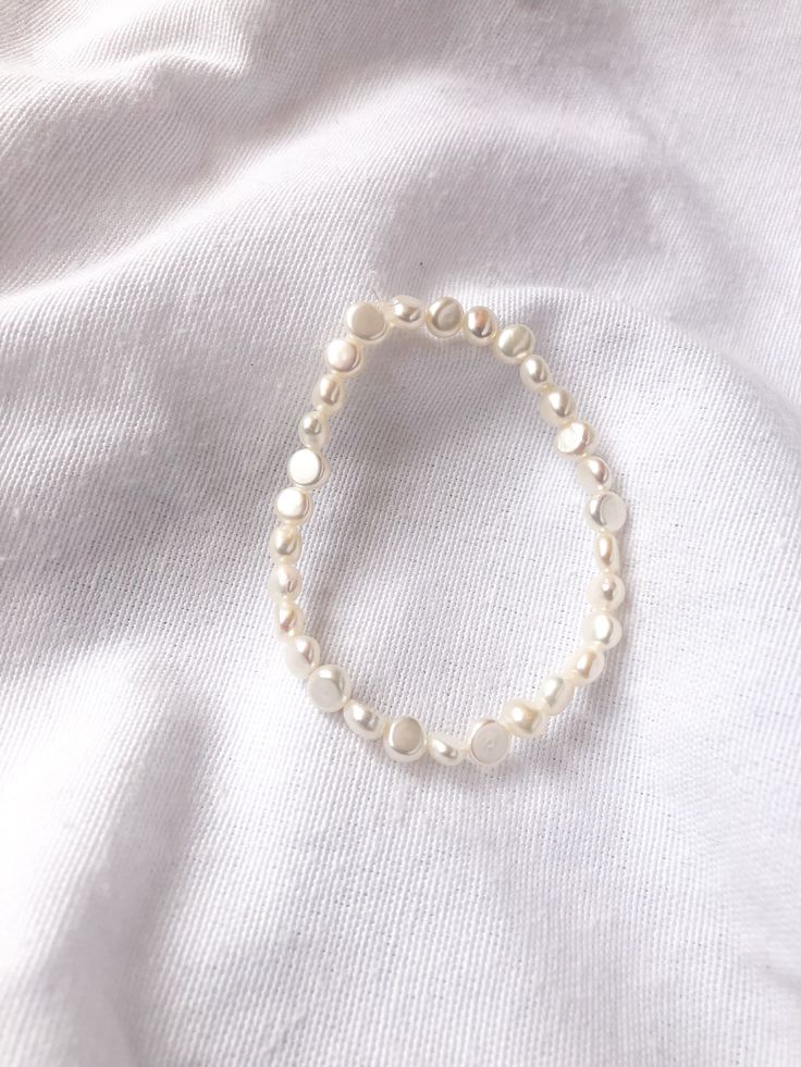 This stretchy bracelet is 6.5 inches. White Wristband For Everyday Use, Handmade Flexible White Bracelets, Handmade Elegant Stretch Bracelet, Elegant Handmade Stretch Bracelet, Handmade Stretch Bangle Bracelet, Trendy Hand-strung Stretch Bangle Bracelet, Elegant Stretch Beaded Bracelets, Stackable Flexible Stretch Bracelet, Adjustable Flexible Stretch Bracelet For Everyday