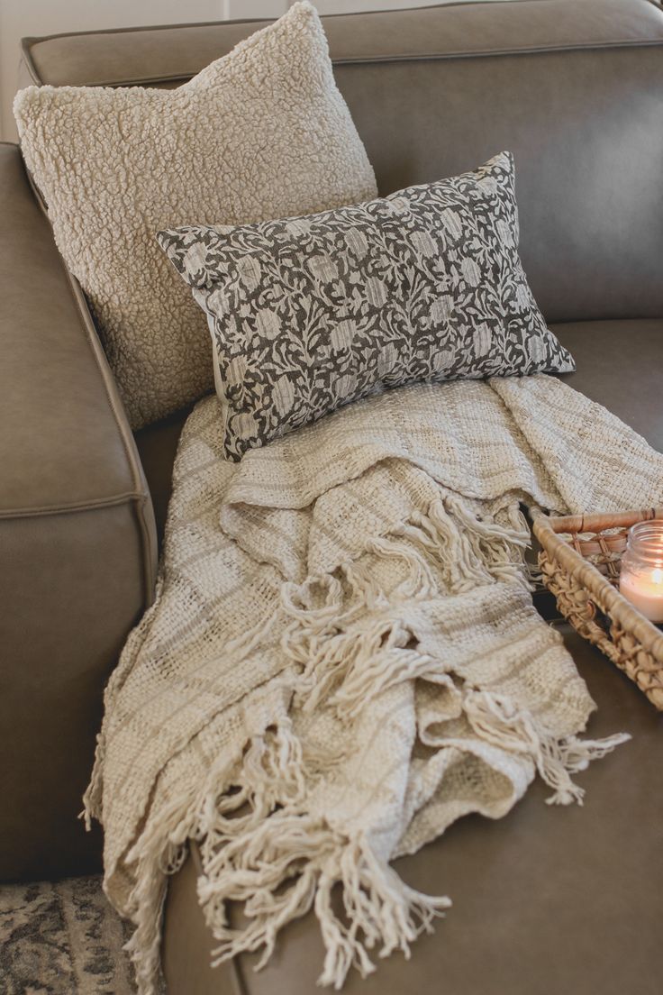 a couch with a blanket and some candles on it