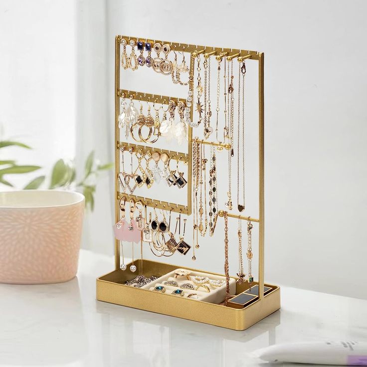 a gold jewelry organizer on a white table