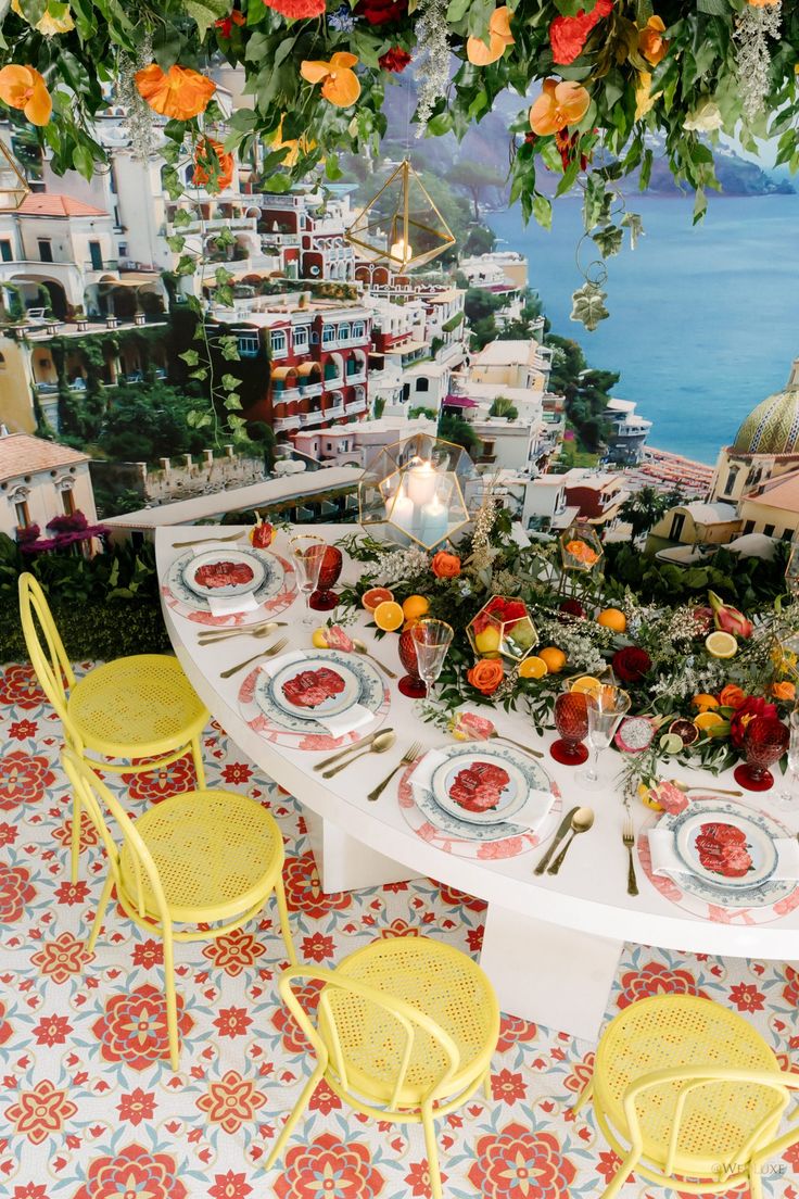 the table is set with yellow chairs and plates