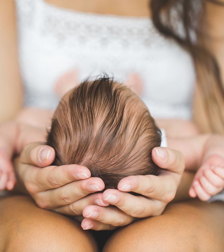 a woman holding her baby's head while sitting down