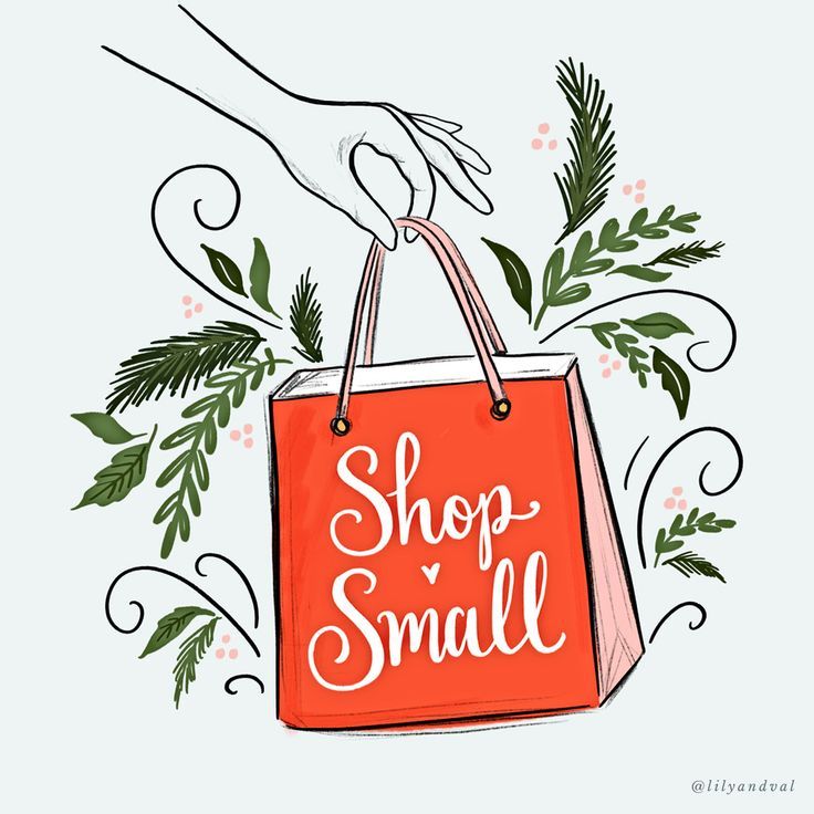 a hand holding a red shopping bag with the words shop small written in white on it