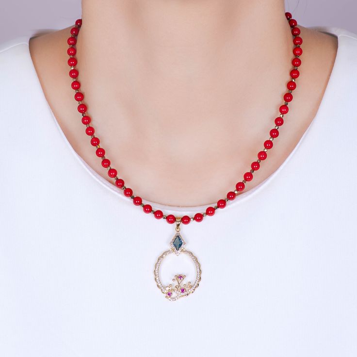 Doris Red Coral Gemstone Bead Necklace DESIGN DETAILS:This beautiful natural stone bead necklace is made with 5mm red coral gemstone beads. With an abstract coral reef design, the pendant features blue, ruby red, peridot green and white cubic zirconia crystals. There are 2 kinds of gold plating on the pendant. The necklace clasps are gold filled metal.PENDANT NECKLACE DETAILS:- PENDANT LENGTH: 1.75 inches | WIDTH: 1 inches- CHAIN LENGTH: 16 inches + 2 inches extension- CHAIN CLOSURE: Lobster Cla Coral Reef Design, Beaded Necklace Designs, Coral Gemstone, Peridot Green, Necklace Clasps, Stone Beaded Necklace, Gemstone Beaded Necklace, Necklace Design, Metal Pendant