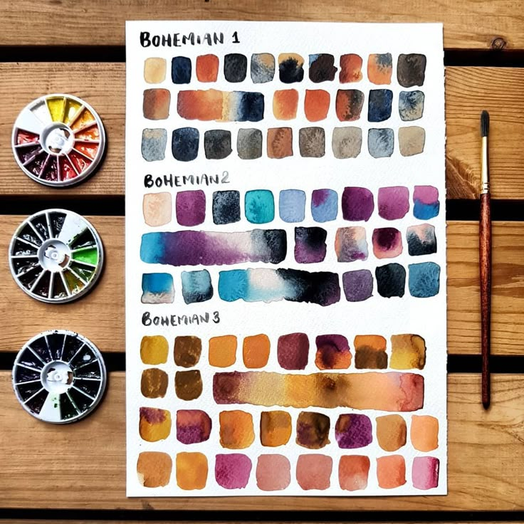 watercolor swatches are arranged on a wooden table