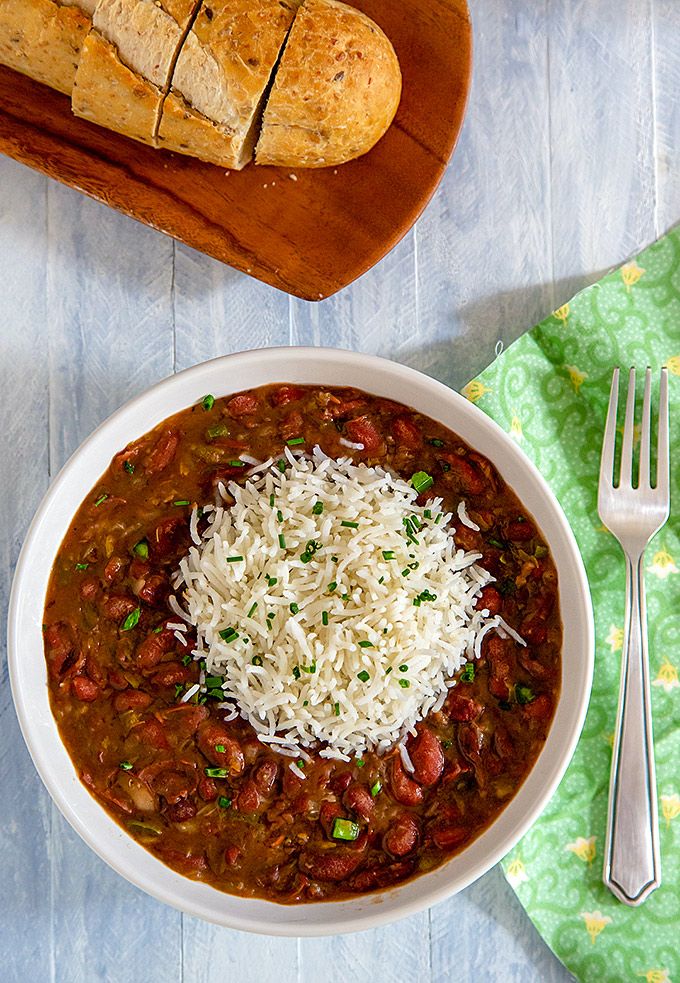 a bowl of chili with cheese and bread on the side