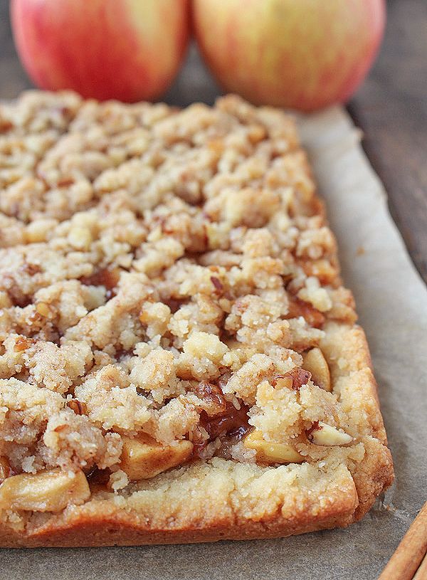 a close up of a pastry on a piece of paper with two apples in the background