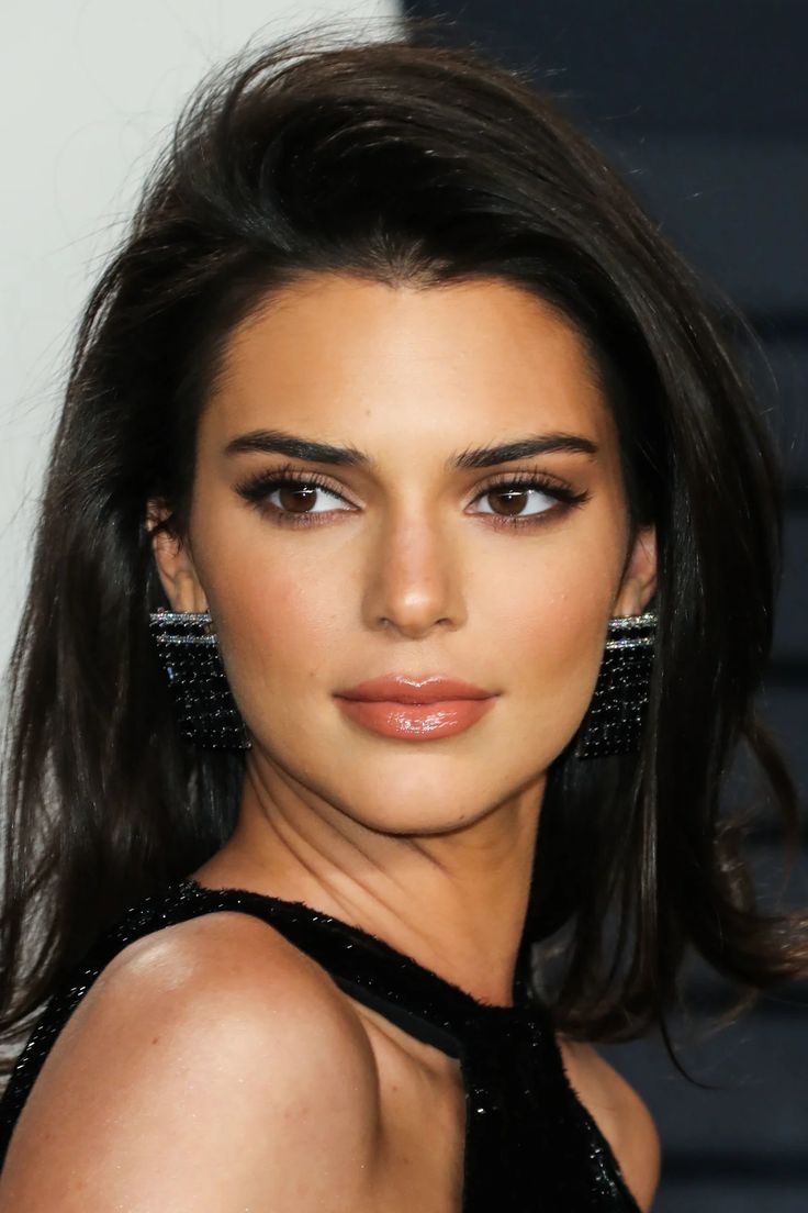 an image of a woman with long hair wearing black dress and earrings on her head