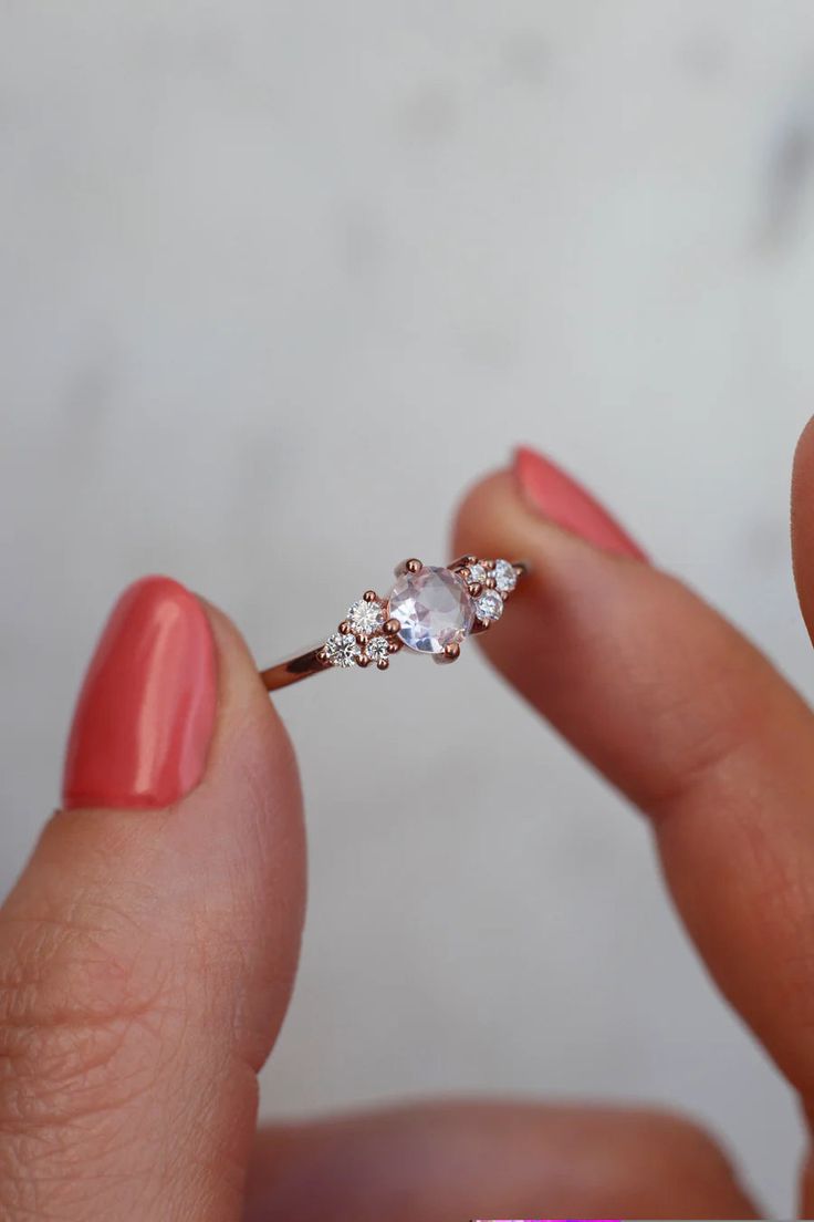 a woman's hand holding a diamond ring