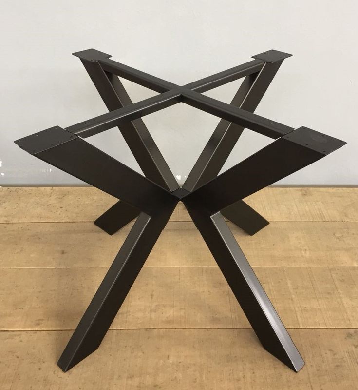 a black metal table with three intersecting legs