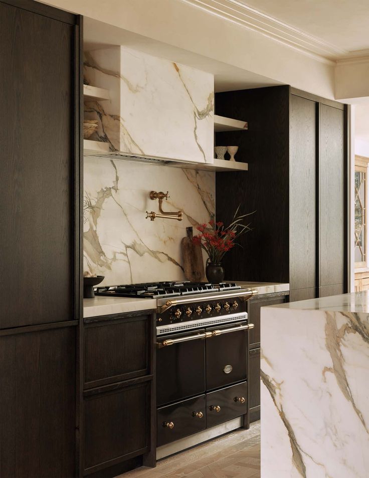 a kitchen with marble counter tops and black cabinetry, along with an oven in the center