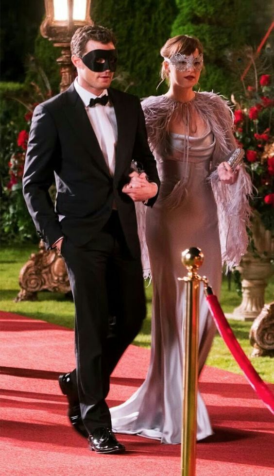 a man and woman in formal wear standing next to each other on a red carpet